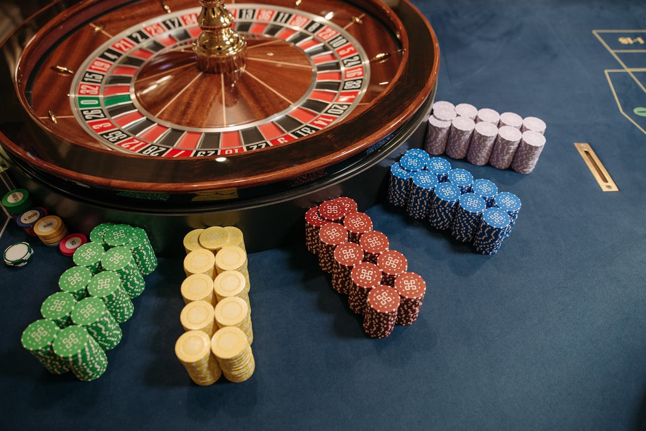 Picture of a roulette wheel with neat stacks of casino chips placed around it